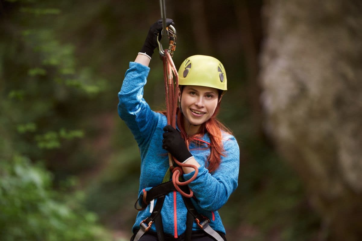 Adventurer sliding into a rainforest pool during Xclusive Adventures canyoning in Kitulgala